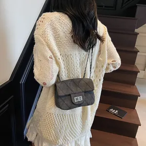 Elegante dunkelgraue Stepp-Umhängetasche mit Silberverschluss auf beigem Strickcardigan