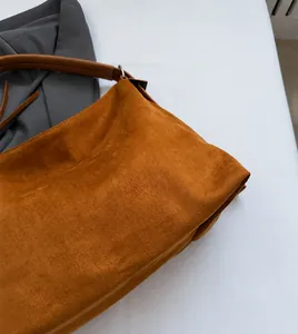 Detalle del bolso tote de ante color caramelo con textura suave y correa de cuero