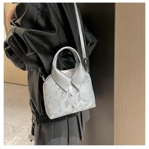 Detailed view of silver shirt-collar designer crossbody bag with metallic leather texture