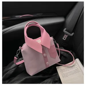 Detail of creative pink shirt-shaped crossbody bag with collar and metal strap on car seat