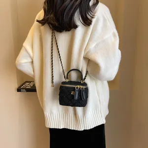 Elegante borsa a tracolla in tweed nero con catena dorata indossata da una modella