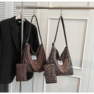 Detailed close-up of leopard print canvas tote bag with adjustable strap and mini pouch