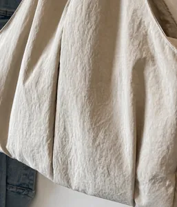 Detail of the lightweight beige oxford fabric texture and fine stitching on the tote bag