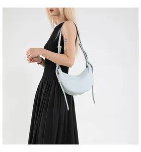 Détail du sac hobo bleu clair en cuir grainé avec inscription fashion et bandoulière
