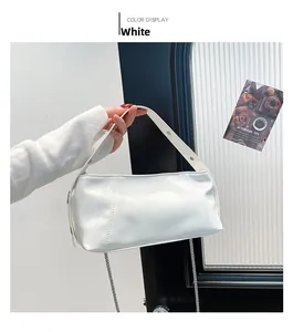 Detail of white PU leather handbag with silver buckle and wide shoulder strap