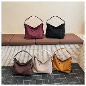 Detalle de cinco bolsos hobo vintage de ante con cremalleras de flecos en varios colores