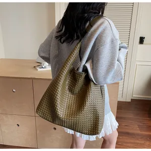 Close-up of olive green woven leather texture on a large capacity shoulder tote bag