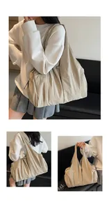 Detail of the pleated texture and wide shoulder strap on the beige nylon tote bag