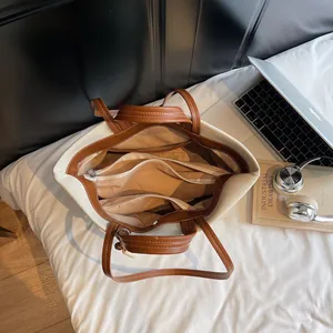 Canvas tote bag with brown trim and dual handles for daily office commute use