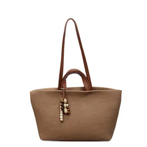 Brown canvas large tote bag with leather handles and decorative wood beads charm