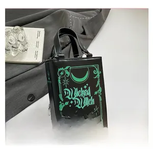 Detail of vintage book-shaped crossbody bag with glowing Wicked Witch gothic design