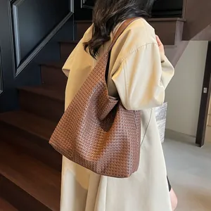 Brown woven leather hobo shoulder bag shown on model with minimalist modern style