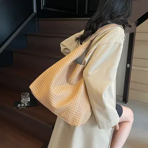 Khaki woven leather tote bag for women with large capacity shown on a shoulder