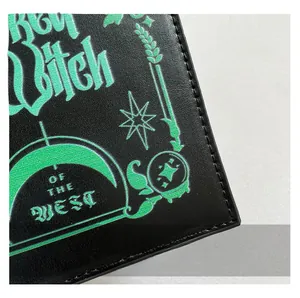 Macro detail of witch-themed green printing on black lychee grain leather bag surface