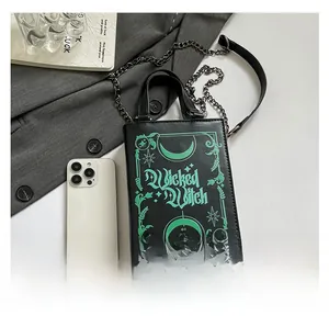 Size comparison of book-shaped crossbody bag with phone for scale and chain detail