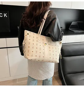 Detail of a large cream tote bag with rabbit patterns worn by a model in a modern interior