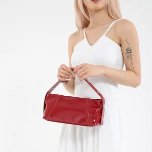 Glossy red patent leather cylinder crossbody bag with retro minimalist design