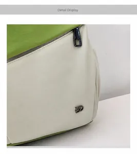 Detail van groen en beige leren rugzak met zilveren rits en metalen merklogo