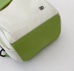 Macro-opname van tweekleurige sporttas met nauwkeurig stiksel en metalen logo-plaatje