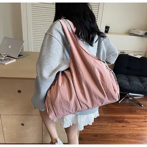 Detail view of large capacity pleated shoulder bag in dusty rose pink with drawstrings