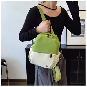 Detalle de mochila bicolor en nailon resistente al agua verde y blanco con cierres metálicos