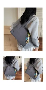 Détail du sac cabas en toile gris foncé avec poche à pression et breloque étoile chic