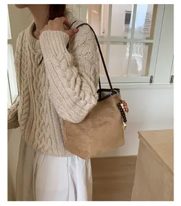 Λεπτομέρεια της tote τσάντας από καστόρι camel με καφέ λουράκι και διακοσμητικές χάντρες
