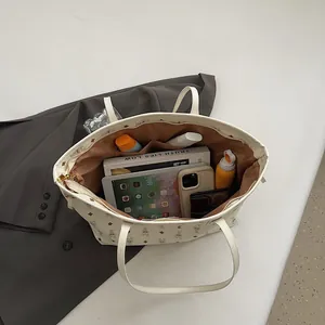 Spacious cream tote bag with rabbit print and brown lining holding daily essentials