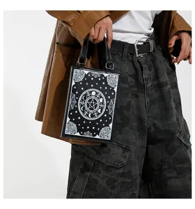 Detail of black gothic book-style handbag with mystical occult symbols and moon phase print