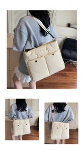 Detail of cream quilted nylon messenger bag featuring double front pockets and black buckles