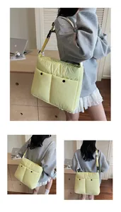 Detail view of yellow quilted tote bag showing double pockets and adjustable strap