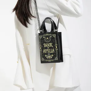 Gothic book-shaped crossbody bag with gold Book of Spells print and moon phases patterns