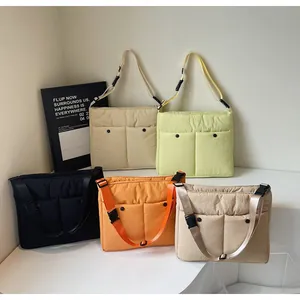 Row of five colorful quilted crossbody bags with dual front pockets on steps