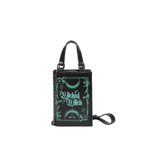 Black book-shaped crossbody bag with green Wicked Witch of the West print and chain strap
