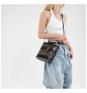 Side view of trendy leopard print bucket bag styled with casual white top and blue jeans