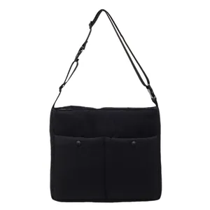 Minimalist black nylon messenger bag with dual front pockets and adjustable strap