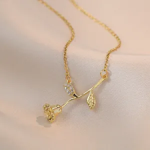 Elegante collana con rosa dorata e foglia di zircone su sfondo di seta, gioiello romantico