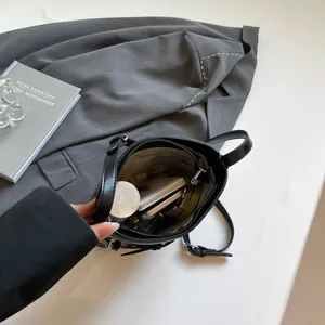 Chic black glossy leather bucket bag with adjustable strap and spacious interior