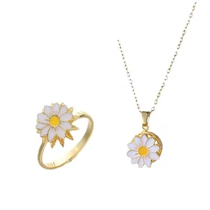 Detailaufnahme von goldenem Gänseblümchen-Schmuckset mit weißen Emaille-Blüten