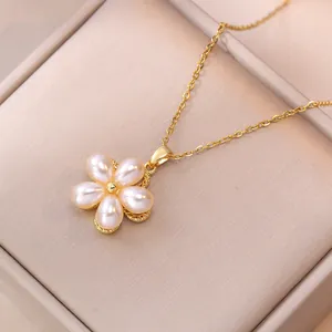 Gros plan détaillé du collier fleur dorée avec pétales en perles dans un écrin à bijoux