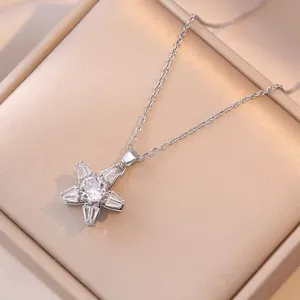Close-up of a silver-tone necklace with a zircon-encrusted star pendant on a velvet box