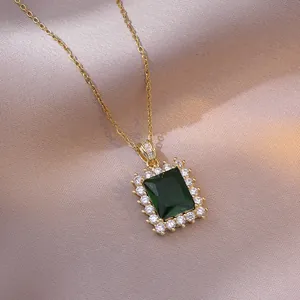 Elegante collana in titanio dorato con ciondolo in zircone verde smeraldo e cristalli