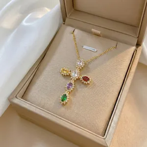Detailed shot of a colorful zircon cross pendant necklace displayed in a beige jewelry gift box
