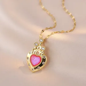 Detailopname van hartvormige hanger met roze glitter en zirkoon op gouden ketting