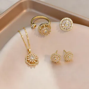 Primo piano di un set di gioielli dorati con ciondoli a forma di sole su seta color champagne