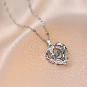 Detail von Herzanhänger mit blauem Edelstein und Zirkonia auf Seidenstoff