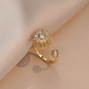 Verstelbare gouden ring met roterende bloem en zirkoonstenen op zijden stof