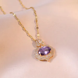 Elegant gold pendant necklace featuring oval purple gemstone and white zircon on silk fabric