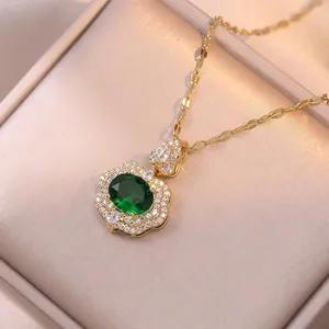 Golden necklace with emerald green gemstone pendant and micro-pave diamonds in jewelry box