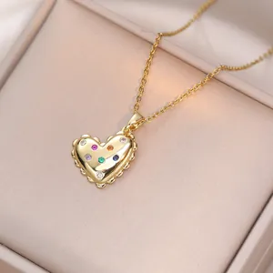 Collier cœur doré avec des pierres en zircon colorées sur une chaîne fine dans un écrin